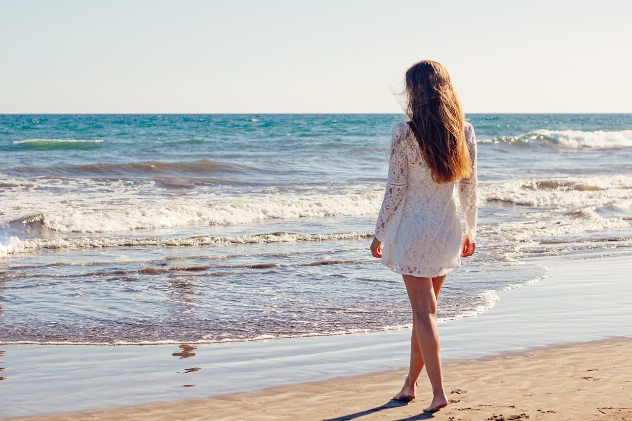 woman at the beach in her summer wedding dress
