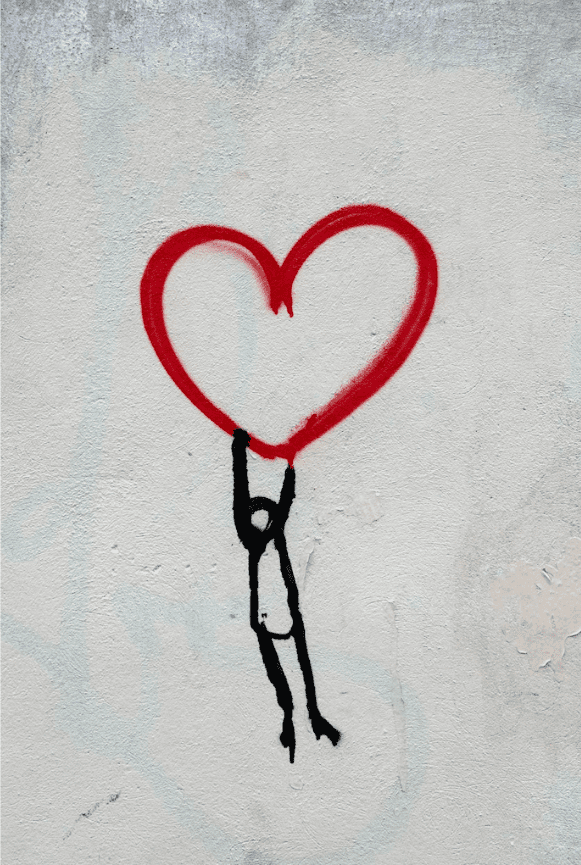 A piece of street art depicting a character holding onto a heart
