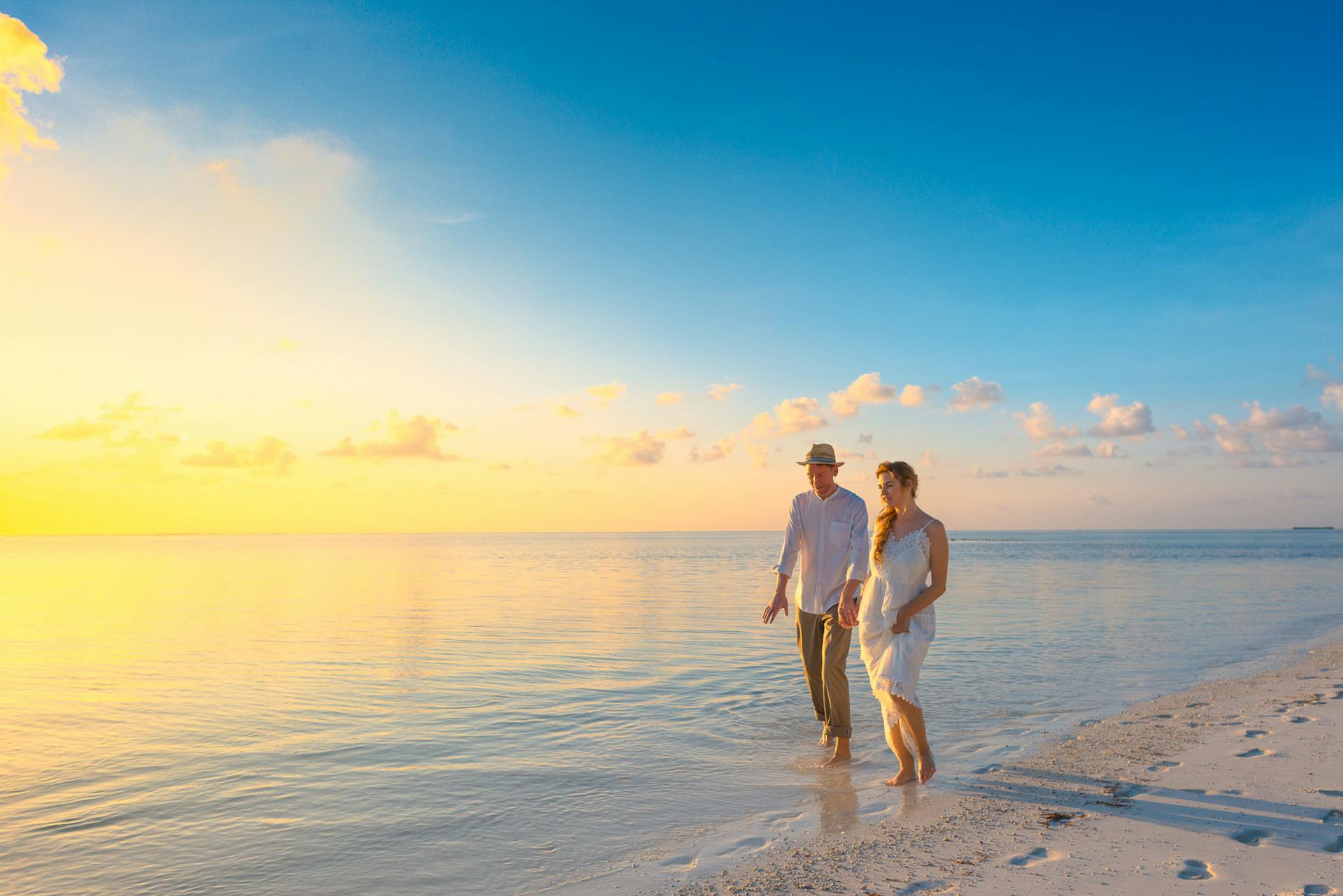 A newly wedded couple walking on a beach in Australia