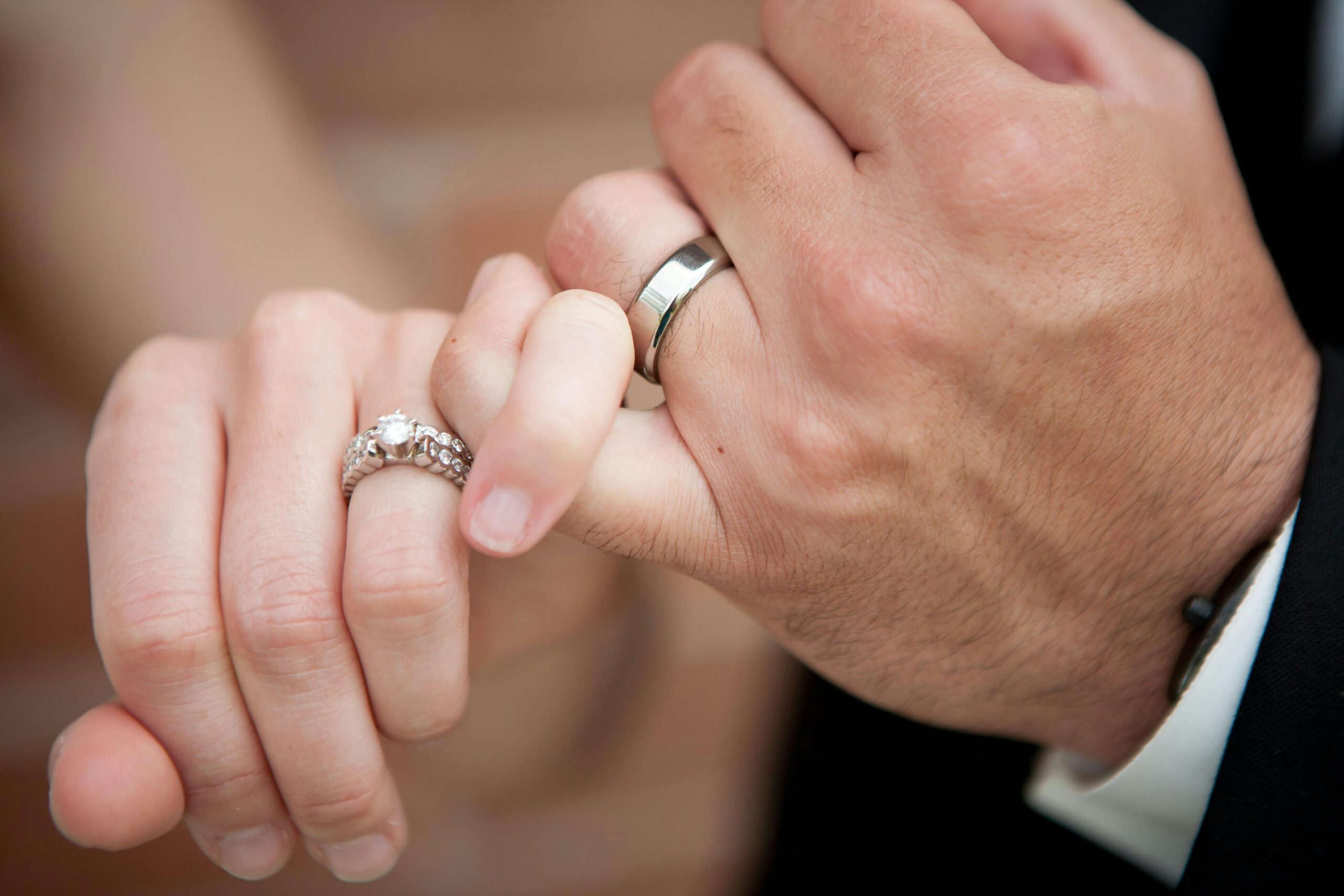 A picture showing the hands of a couple wearing their wedding rings
